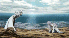 a man in a white robe is standing next to a woman in a pink dress on a hill overlooking the ocean .