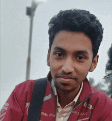 a man wearing a red jacket with the word inal on it
