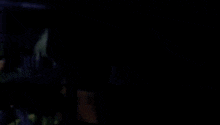 a person is sitting at a desk in a dark room with a lamp on .