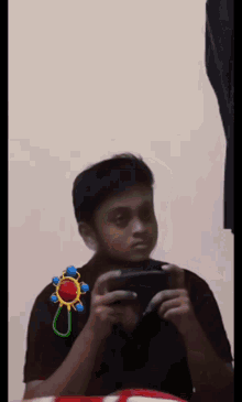 a boy playing a video game with a baby rattle on his arm