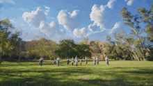 a group of people standing in a circle in a grassy field