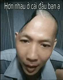a man with a shaved head looks at the camera with the words hon nhau o cai dau ban a written below him