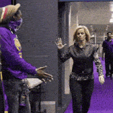 a man in a purple shirt with a lanyard that says lsu