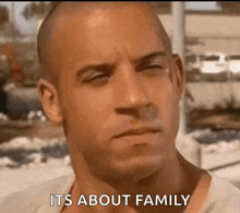 a close up of a man 's face with the words `` its about family '' written on it .