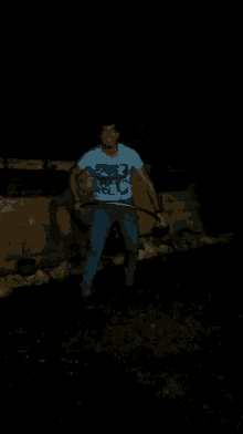 a man wearing a blue shirt that says ' california ' on it stands in the dark
