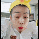 a woman wearing a yellow headband and red lipstick is making a face .
