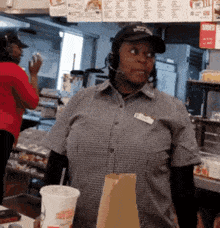 a woman wearing headphones and a hat that says pizza hut on it