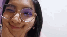 a close up of a woman wearing glasses and making a face .