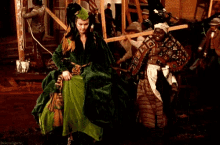 a woman in a green dress stands next to another woman