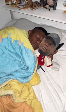 a man laying on a bed with a stuffed mickey mouse