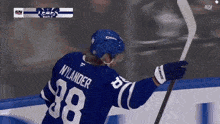 a hockey player with the number 38 on his jersey is holding a hockey stick