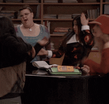 a group of women singing in front of a piano with a book on it that says ' i love you '