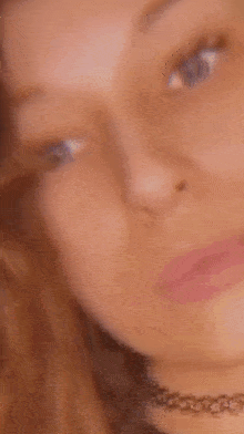 a close up of a woman 's face with her eyes closed behind a glass .