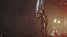 a man singing into a microphone on a stage with the letter d in the corner