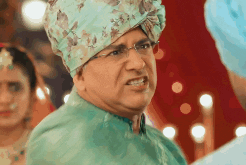 a man wearing a turban and glasses looks angry
