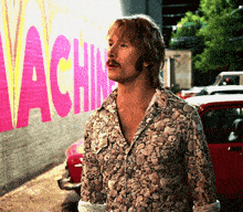 a man is standing in front of a wall that says vachine