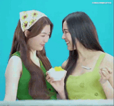 two women are looking at each other and one is holding a bowl of ice cream .