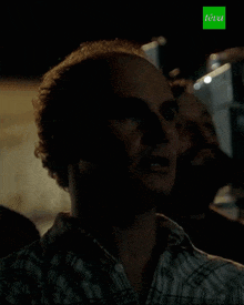a man in a plaid shirt says pas bien in a foreign language