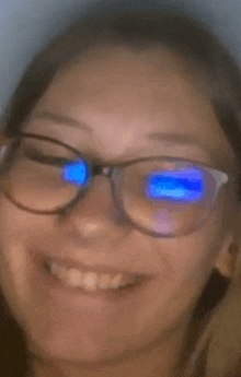 a close up of a woman wearing glasses and smiling