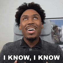 a man in a striped shirt says " i know i know " in front of a microphone