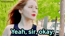 a woman says yeah sir okay in front of a tree