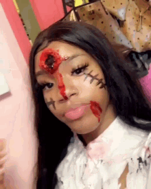a girl with stitches on her face and a hole in her head .