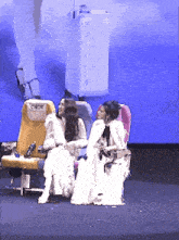 two women are sitting on a stage in front of a screen that says cadt