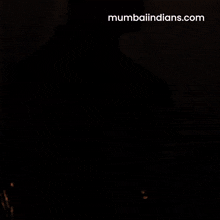 a man with his arms crossed is wearing a blue shirt that says mumbai indians