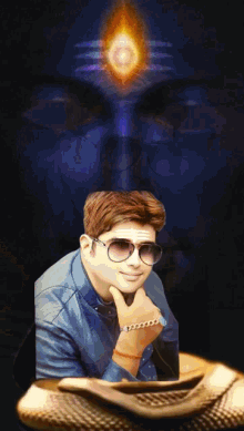 a man wearing sunglasses stands in front of a picture of a shiva