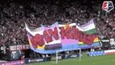 a soccer field with a banner that says we are family on it