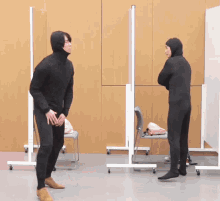 a man in a hooded sweater is standing next to another man in a hooded sweater