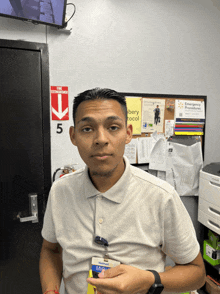a man wearing a walmart id card stands in front of a fire extinguisher
