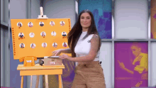 a woman is standing in front of an easel with tvz written on it