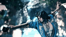 a man in a blue shirt is dancing in the rain while holding a ball