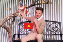 a man sitting on a bench holding an american flag