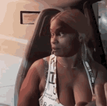 a woman is sitting in the back seat of a car wearing a tank top that says tender and private
