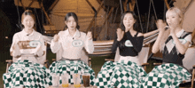 a group of young women are sitting at a table with a checkered table cloth