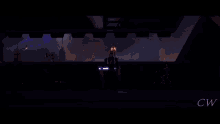 a silhouette of a person holding a lightsaber in front of a burning building