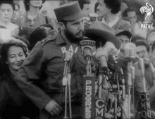 a black and white photo of a man speaking into a microphone that says progress