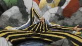 a man in a black and yellow striped suit is laying down