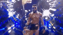 a man without a shirt is holding a trophy in a tunnel .