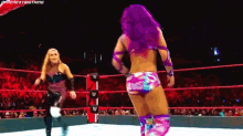a woman with purple hair is standing in a wrestling ring next to another woman