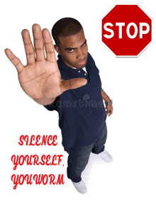 a man holds up his hand in front of a red stop sign