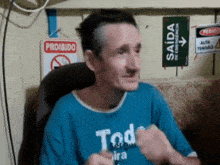 a man wearing a blue shirt that says todo tira