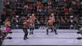 a group of wrestlers in a ring with a aew logo on the wall