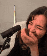 a woman laughs in front of a microphone