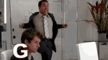 a man in a suit and tie is standing in front of a whiteboard that says get the f