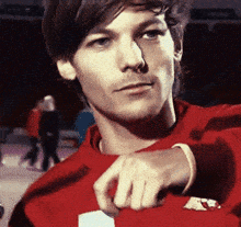 a young man wearing a red sweater with the letter a on the front