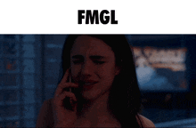 a woman is crying while talking on a cell phone and the word fmgl is above her