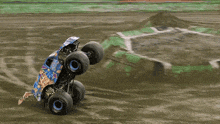 a monster truck is doing a trick on a dirt road
